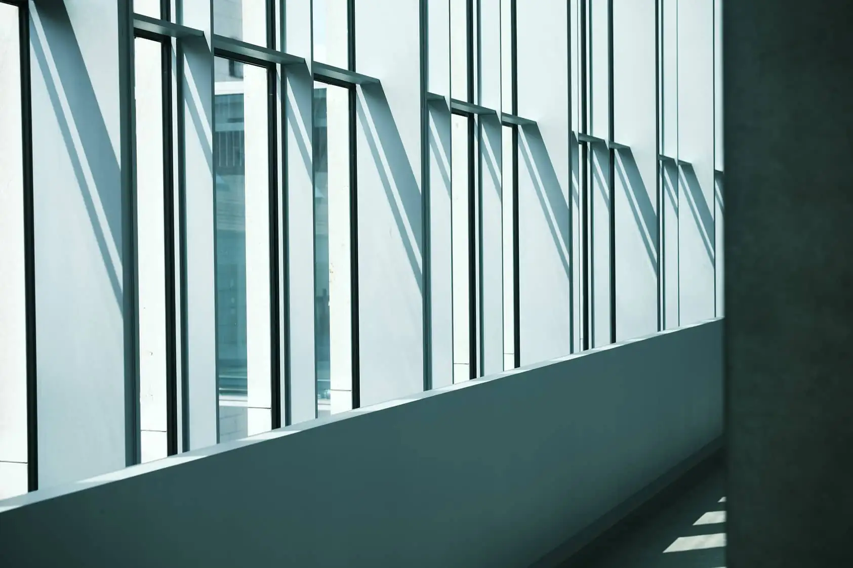 Façade vitrée d'un immeuble de bureaux moderne, lumière et ombres portées, illustration des actifs tertiaires des SCPI Sofidy