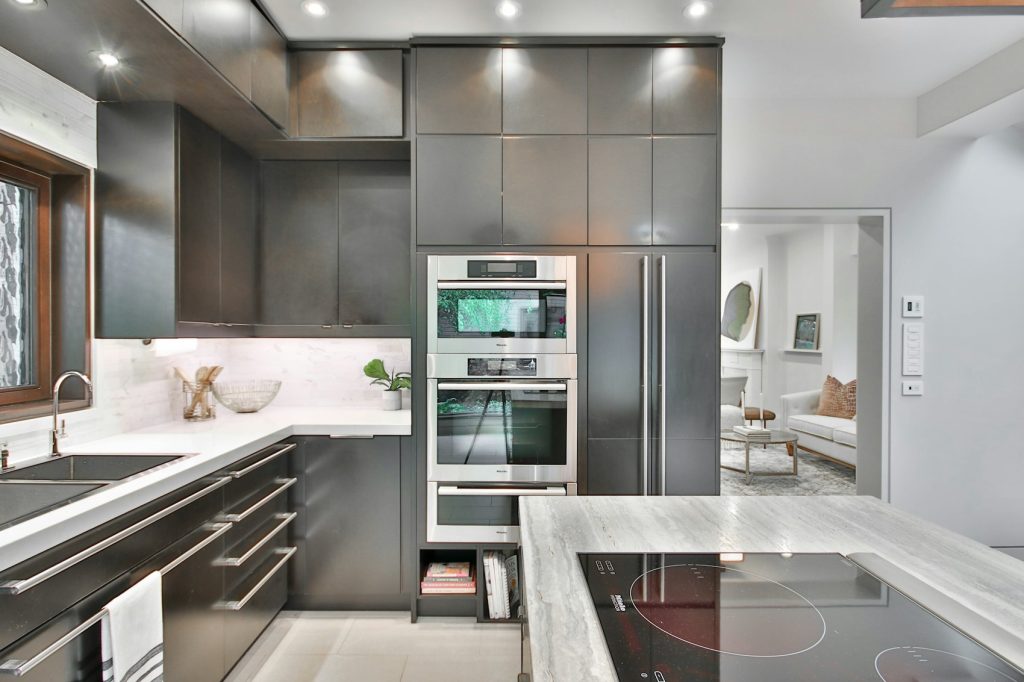 Cuisine équipée avec électroménager inox et plans en marbre - photo d'illustration, programmes Cogedim
