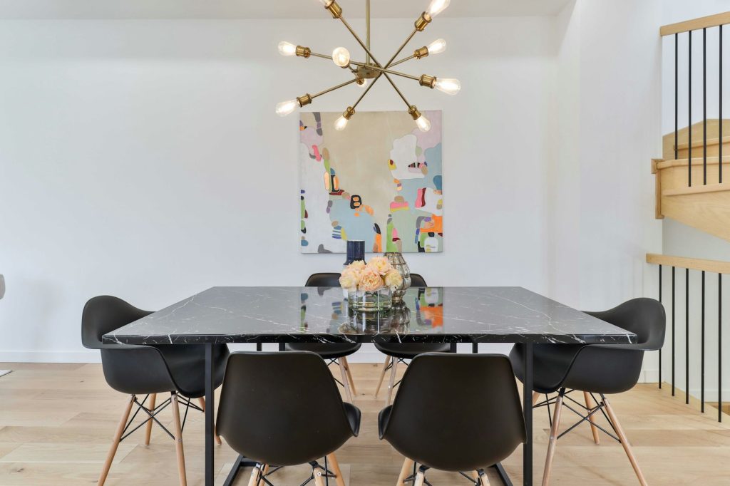 Salle à manger avec table en marbre et chaises noires - photo d'illustration, programmes Urbat